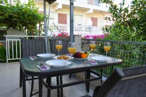 uma mesa com copos de vinho e frutas numa varanda em Anastasia mare home #A# em Rethymno Town