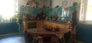 a kitchen with a table with a bowl of fruit on it at Chambre dans maison mosaïquée in Saint-Marcel