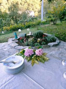 un tavolo con piatti e fiori sopra di B&B Casa dell'Orso a Lurisia
