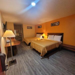 a hotel room with two beds and a lamp at La Vista Motel in Brownsville