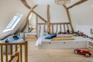 a attic bedroom with two beds and a red toy car at cottage maison de campagne Normandie house Normandy in Berthouville