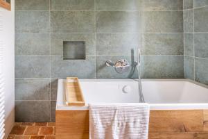 a bathroom with a white tub in a room at cottage maison de campagne Normandie house Normandy in Berthouville +39 photos