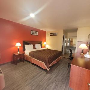 a hotel room with a bed and two lamps at La Vista Motel in Brownsville