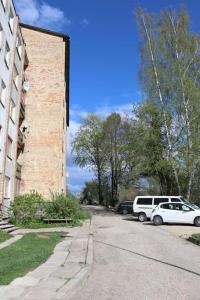 una calle con coches estacionados al lado de un edificio de ladrillo en Dzīvoklis ar skatu pār Alūksni en Alūksne