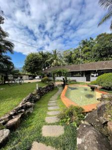 einen Garten mit Pool und ein Haus in der Unterkunft Recanto R-12 in Rodeio Doze