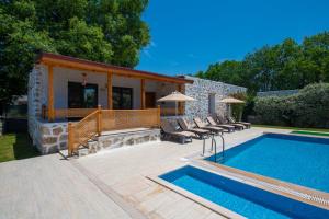 a patio with a pool and chairs and a house at Eroğlu Villas in Fethiye