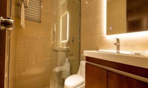 a bathroom with a shower and a toilet and a sink at FabHotel Prime Manasa Inn in Tirupati