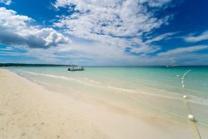 a boat in the water on a beach at Blue Skies Beach Resort in Negril
