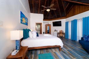 um quarto com uma cama e uma ventoinha de tecto em Blue Skies Beach Resort em Negril