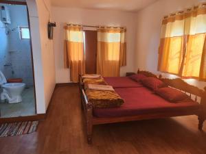 a bedroom with two beds and a bathroom with a mirror at Belair cottages in Kotagiri