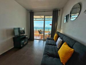 a living room with a couch and a television at Domuum Holidays - RODAS in Salou
