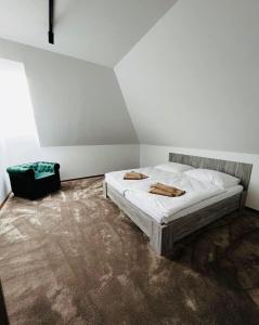 1 dormitorio con 1 cama con 2 toallas en Kaštiel Boncz, en Dvory nad Žitavou