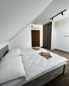 1 dormitorio con 1 cama blanca grande y 2 mantas en Kaštiel Boncz, en Dvory nad Žitavou