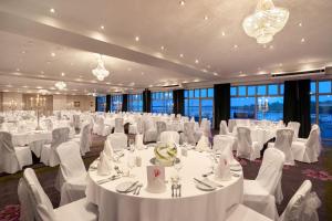 une grande salle de banquet avec des tables et des chaises blanches dans l'établissement Ferrycarrig Hotel, à Wexford