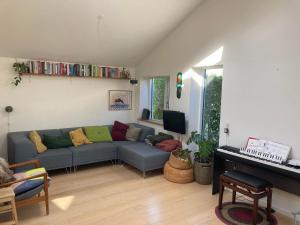 uma sala de estar com um sofá e um piano em ApartmentInCopenhagen Apartment 1323 em Copenhaga