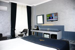 alfin otel في أنقرة: غرفة في الفندق بها سرير وتلفزيون على الحائط