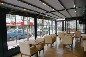 a dining room with tables and chairs and windows at alfin otel in Ankara