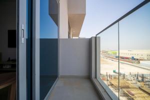 an office building with a view of a city from a window at ALH Vacay - Brand New Studio in Azizi Aura Jebel Ali in Dubai