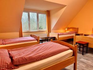 um quarto com três camas e uma janela em Nordsee Jugendheim Delphin em Husum