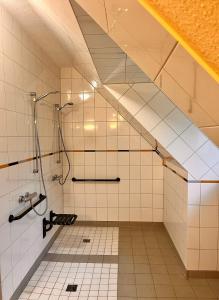 uma casa de banho com um chuveiro num quarto em Nordsee Jugendheim Delphin em Husum