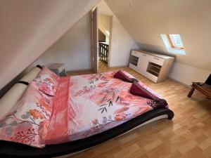 a bedroom with a bed with a pink blanket at La maison des camélias in Le Tampon