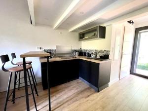 - une cuisine avec un comptoir et des tabourets dans une pièce dans l'établissement Ravissant appartement à 5min du centre ville d'Aix, à Aix-en-Provence