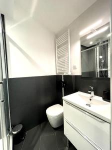 La salle de bains est pourvue de toilettes blanches et d'un lavabo. dans l'établissement Ravissant appartement à 5min du centre ville d'Aix, à Aix-en-Provence