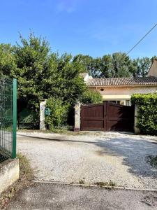 une maison avec une clôture brune et une allée dans l'établissement Ravissant appartement à 5min du centre ville d'Aix, à Aix-en-Provence