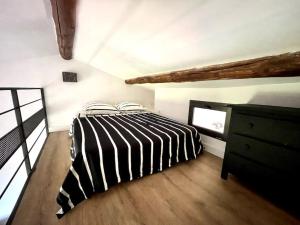 - une chambre avec un lit noir et blanc et une commode dans l'établissement Ravissant appartement à 5min du centre ville d'Aix, à Aix-en-Provence