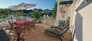 伦Kuća Ugor的带桌椅和遮阳伞的露台