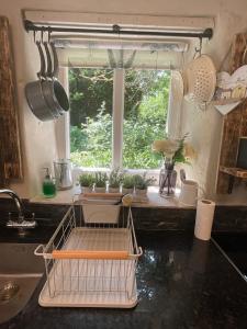 a kitchen with a dish drying rack and a window at The Old Chapel Annexe in Helston