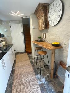 a kitchen with a table and a clock on the wall at The Old Chapel Annexe in Helston
