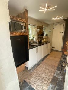 a kitchen with a sink and a microwave at The Old Chapel Annexe in Helston