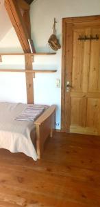 a bedroom with a bed and a wooden floor at Mājīga istaba ar balkonu un vannasistaba, bezmaksas elektroauto uzlāde in Iecava