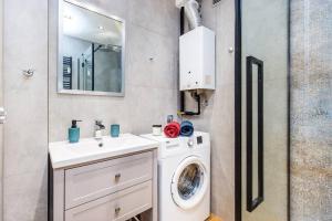 uma casa de banho com uma máquina de lavar roupa e um lavatório em Serene Apartment in the City Center em Cracóvia