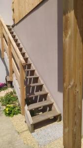 una escalera de madera junto a una pared con una escalera en studio tout équipé, en Saint-Étienne-de-Montluc