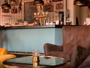 a bar with a leather chair and a table at City Hotel in Kristinehamn