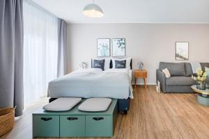 a bedroom with a large bed and a couch at limehome Metzingen Wilhelmstr in Metzingen