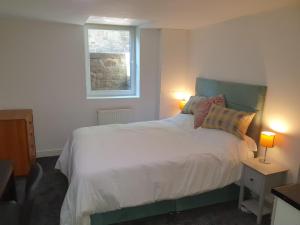 a bedroom with a bed with two lamps and a window at Lyndene House in Huddersfield