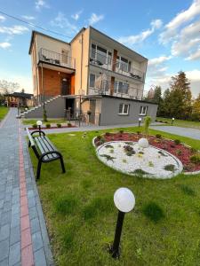 a park with a bench in front of a building at Pensjonat u Tosiek in Stegna