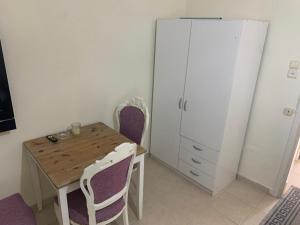 La cuisine est équipée d'une table et de chaises en bois ainsi que d'un réfrigérateur. dans l'établissement משמר הגבול 9 דירה 4, à Haïfa