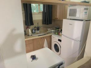 a small kitchen with a white refrigerator and a microwave at משמר הגבול 9 דירה 4 in Haifa