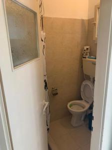 a bathroom with a toilet and a door open at משמר הגבול 9 דירה 4 in Haifa