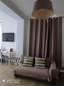 Guest House Iulia في روما: غرفة معيشة مع أريكة وستارة بنية