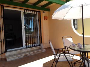 un patio con mesa, sillas y sombrilla en Beach and Pools La Cala Mijas & Fuengirola by H&H, en Fuengirola
