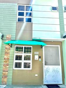 een deur naar een gebouw met een groene luifel bij Rimaven Homes Clark-Dau (w/ Parking, Netflix, Wi-Fi) 