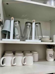 a kitchen shelf with jars and other kitchen items at Rimaven Homes Clark-Dau (w/ Parking, Netflix, Wi-Fi) 