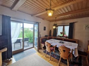 ein Esszimmer mit einem Tisch und einem Balkon in der Unterkunft Haus Luise in Krün