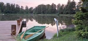 un barco amarrado a un muelle en un lago en Dolina Witówki en Mrozy