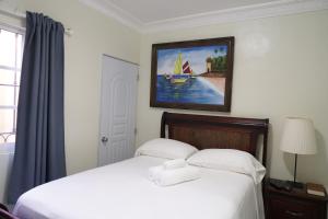 a bedroom with a bed with a painting on the wall at Villa Gumio 2BR Apt- 7 min walk to Boca Chica Beach apts in Boca Chica